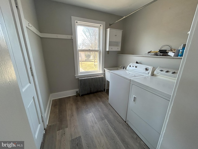 washroom featuring a sink, wood finished floors, washing machine and dryer, radiator, and laundry area