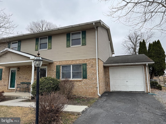 view of front of house featuring a garage, brick siding, covered porch, and driveway