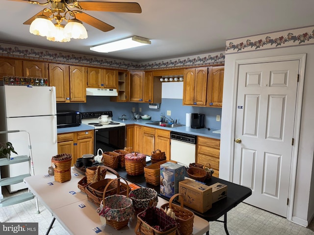 kitchen with white appliances, brown cabinetry, light floors, a sink, and under cabinet range hood