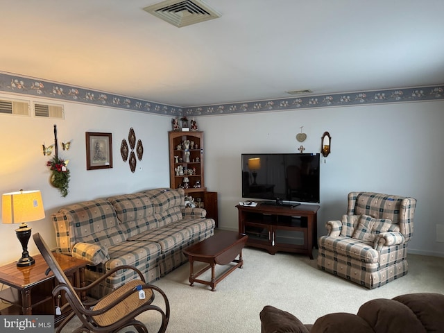 living area featuring visible vents and carpet