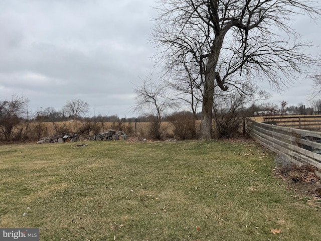 view of yard with a rural view and fence