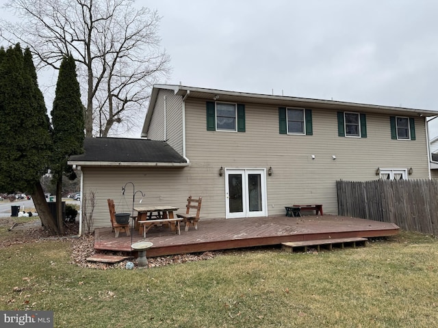 rear view of house featuring a deck, a yard, and fence