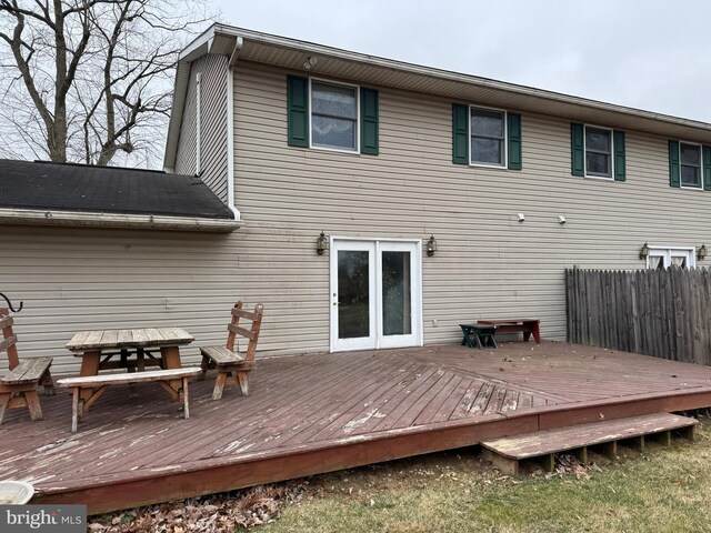 back of property with a deck, outdoor dining space, and fence