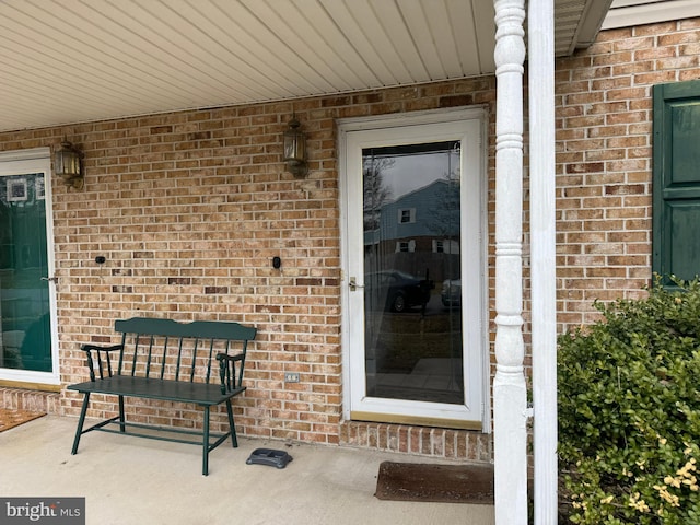 doorway to property with brick siding