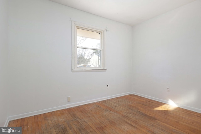 spare room with hardwood / wood-style flooring and baseboards