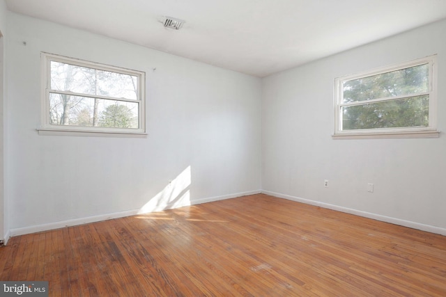 spare room with visible vents, baseboards, and light wood-style floors