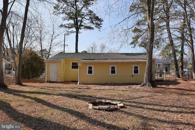 rear view of property with fence and an outdoor fire pit