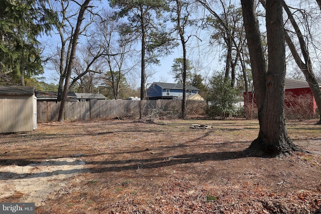 view of yard featuring an outdoor structure and fence