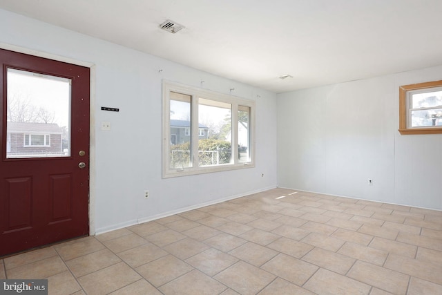 foyer entrance with visible vents, plenty of natural light, and light tile patterned flooring