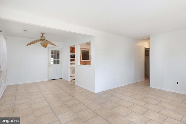 spare room with light tile patterned floors, baseboards, visible vents, and ceiling fan