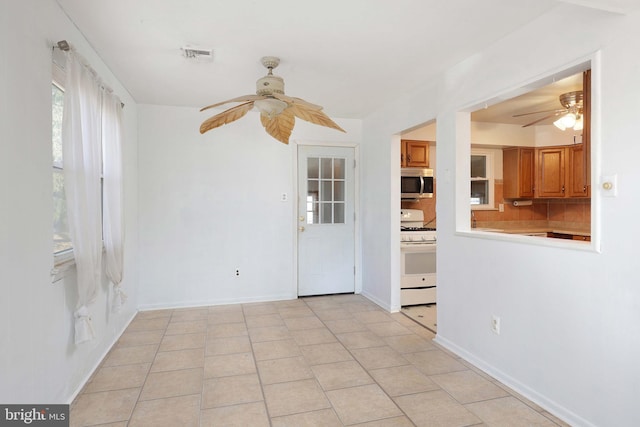 unfurnished room with light tile patterned floors, visible vents, and a ceiling fan