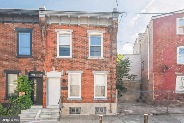 view of front of house with brick siding and fence