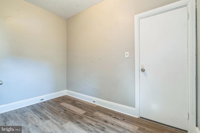 spare room featuring baseboards and wood finished floors