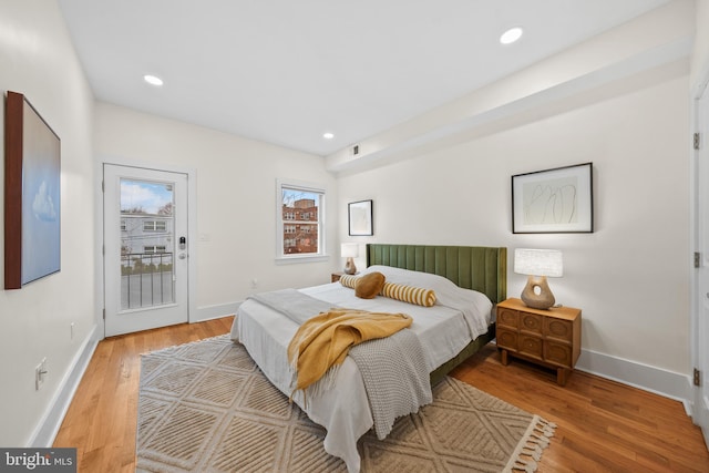 bedroom with recessed lighting, baseboards, wood finished floors, and access to outside