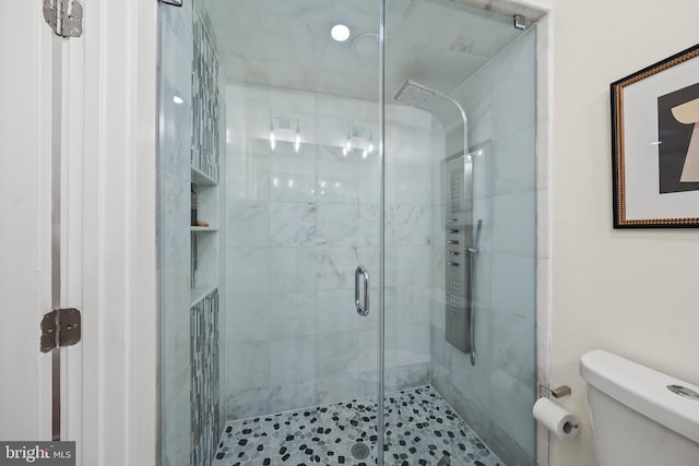 full bathroom featuring a stall shower and toilet