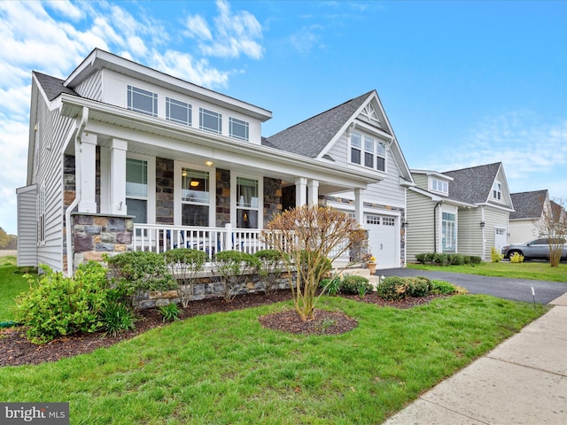 23811 Pembroke Ln, Millville, DE 19967 - craftsman-style home featuring a front yard, an attached garage, stone siding, covered porch, and aphalt driveway