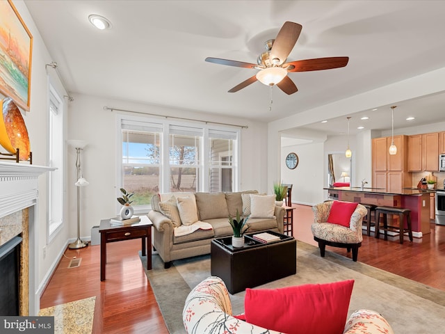 23811 Pembroke Ln, Millville, DE 19967 - living area with recessed lighting, light wood-style flooring, a ceiling fan, visible vents, and a high end fireplace