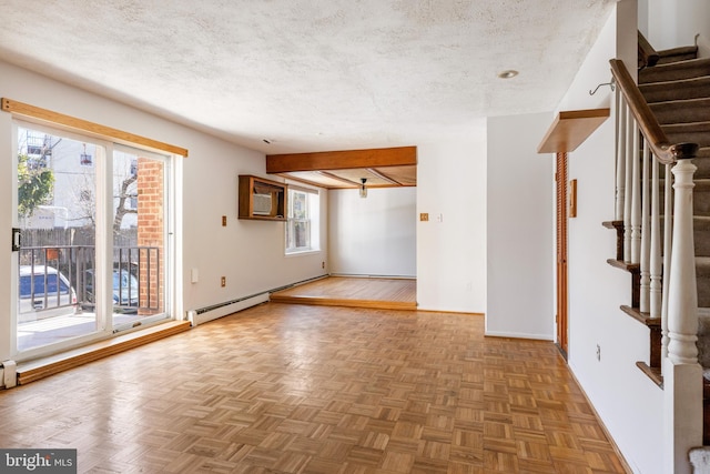 spare room featuring stairway, baseboards, a textured ceiling, and a baseboard heating unit