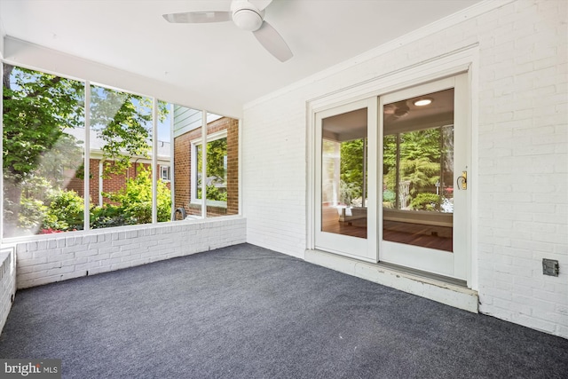 unfurnished sunroom featuring ceiling fan and a wealth of natural light