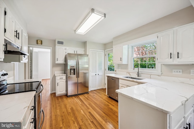 kitchen featuring visible vents, stainless steel appliances, light wood-type flooring, a sink, and under cabinet range hood