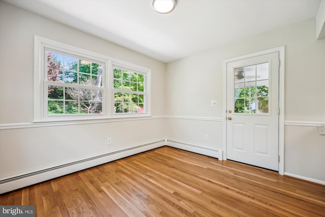 interior space featuring a baseboard heating unit and light wood-style floors