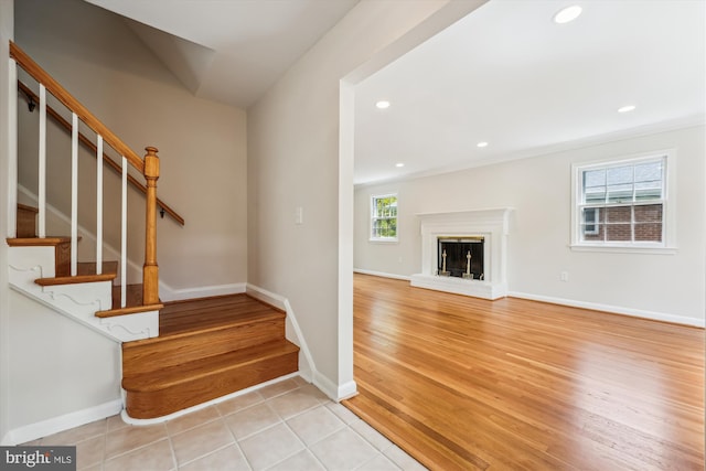 stairs with baseboards, a fireplace, recessed lighting, and wood finished floors