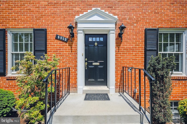 view of exterior entry featuring brick siding