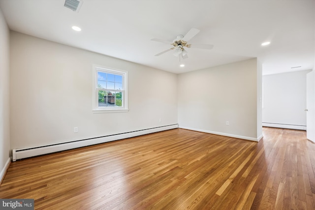 unfurnished room featuring ceiling fan, baseboard heating, wood finished floors, a baseboard radiator, and visible vents