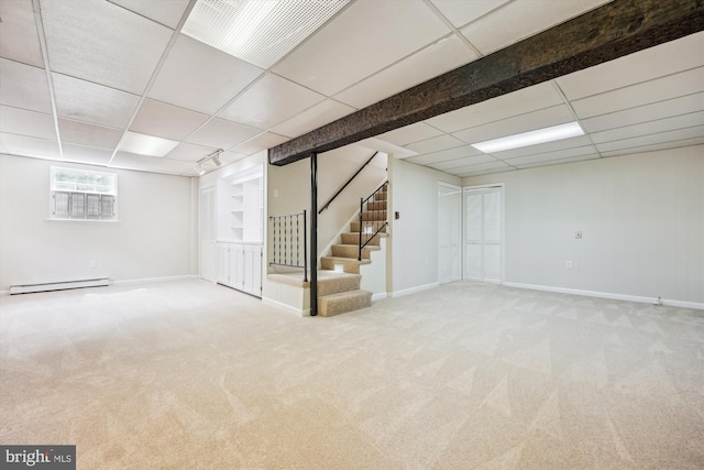 basement featuring carpet, a paneled ceiling, baseboard heating, and stairway