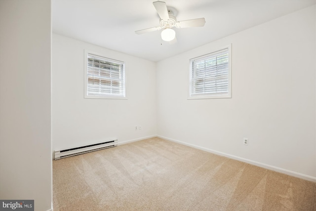 spare room with a baseboard radiator, carpet flooring, and a wealth of natural light