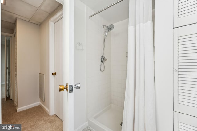 bathroom with baseboards and a stall shower