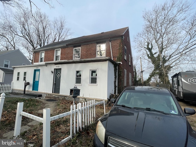 view of front of property featuring brick siding and a fenced front yard