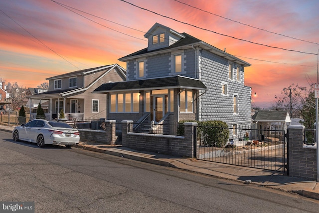 american foursquare style home featuring a fenced front yard and a gate