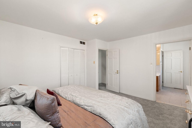 bedroom with a closet, visible vents, and carpet