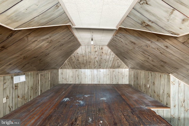 bonus room with vaulted ceiling, wooden walls, and hardwood / wood-style floors