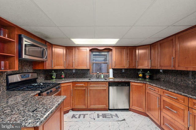 kitchen featuring brown cabinetry, marble finish floor, and stainless steel appliances