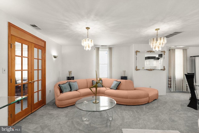 living room with visible vents, french doors, an inviting chandelier, and carpet floors