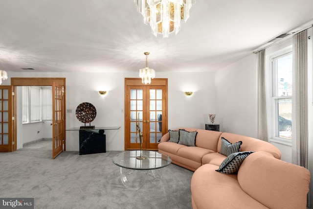 living area featuring a notable chandelier, french doors, visible vents, and carpet floors