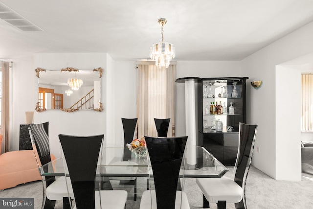 carpeted dining room with visible vents, an inviting chandelier, and stairway