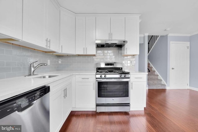 kitchen featuring under cabinet range hood, dark wood-style floors, light countertops, and appliances with stainless steel finishes