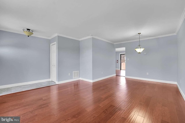 spare room featuring baseboards, wood finished floors, and ornamental molding