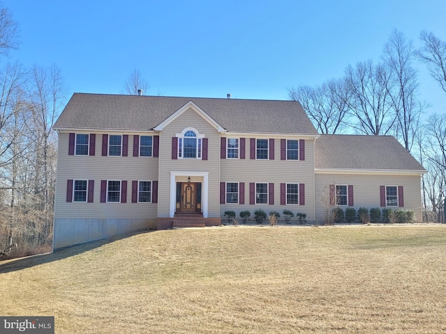 colonial home featuring a front lawn