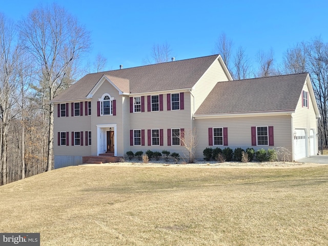 colonial home with a front yard and a shingled roof