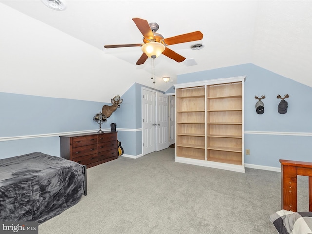 carpeted bedroom with ceiling fan, vaulted ceiling, and baseboards