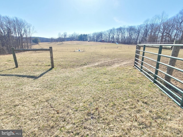 view of yard with fence and a rural view