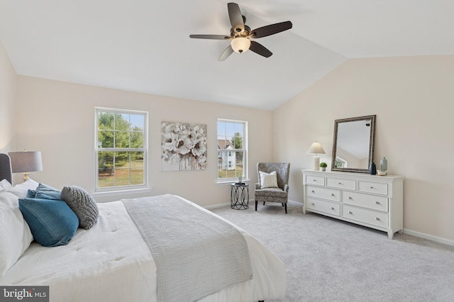 bedroom featuring light carpet, ceiling fan, baseboards, and lofted ceiling