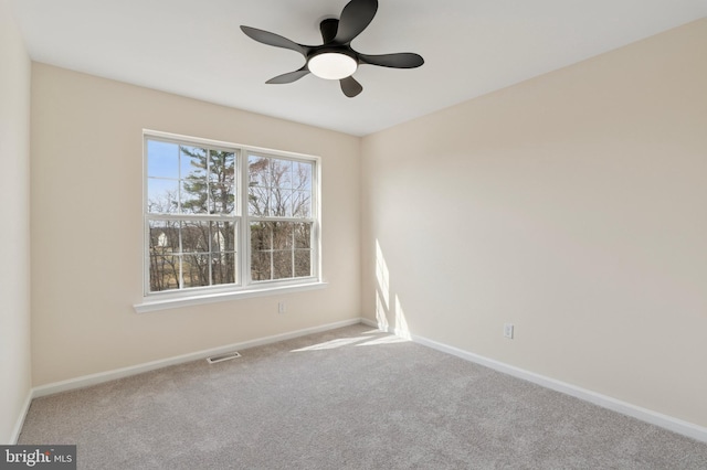 empty room with visible vents, baseboards, carpet, and ceiling fan