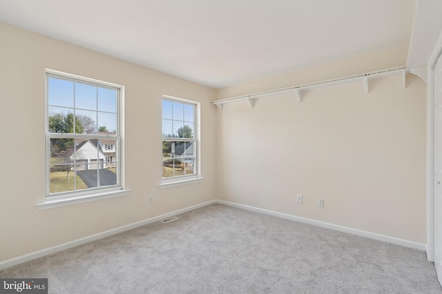 spare room featuring visible vents, baseboards, and carpet floors