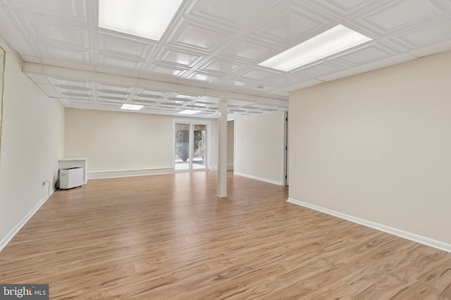 below grade area with light wood-style floors and baseboards