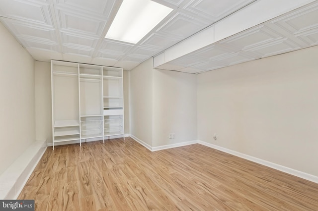 unfurnished bedroom featuring an ornate ceiling, baseboards, and light wood-style floors